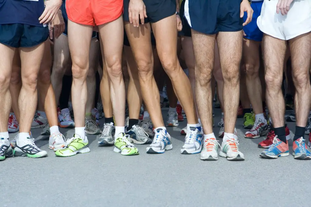 A group of runners wearing shorts displaying their leg muscles