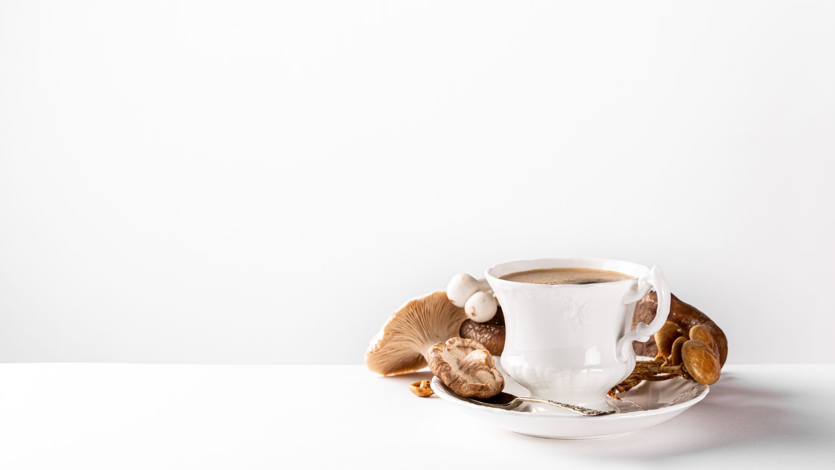 A white cup of mushroom coffee in front of a white background
