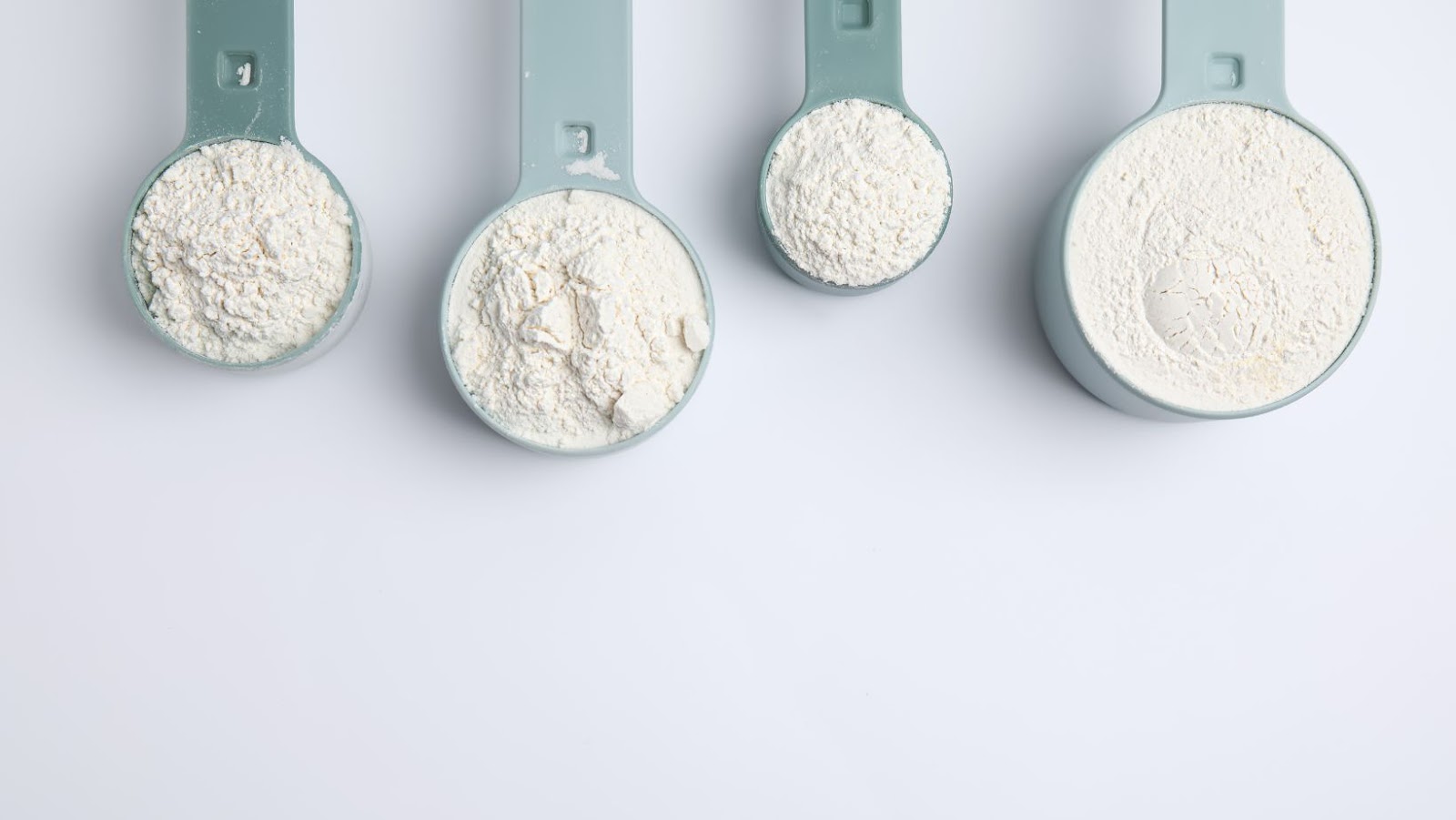A close-up of 4 scoops of creatine powder