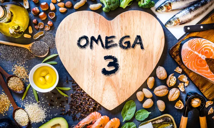 A photo of food items that are rich in omega-3 fatty acids. The food items include salmon, walnuts, flaxseeds, chia seeds, and olive oil. 