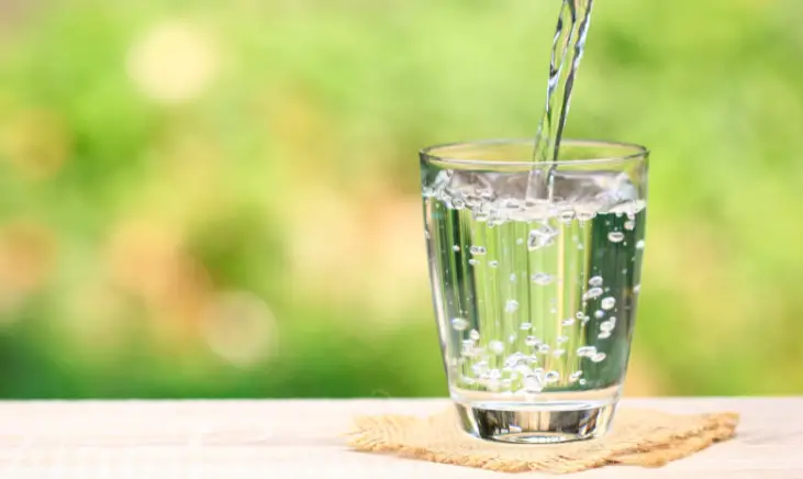 A glass of water with water pouring into it. 