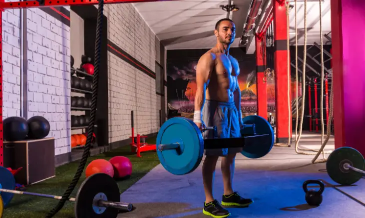 A man doing a trap bar deadlift in a gym