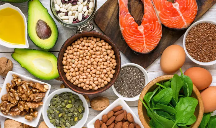 Image of a variety of foods that are high in electrolytes, such as avocados, nuts, seeds, fish, eggs and leafy green vegetable.