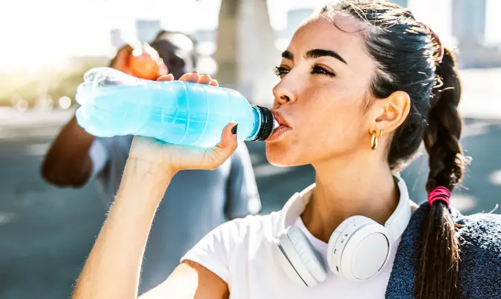 Woman refreshing herself with a cold drink.