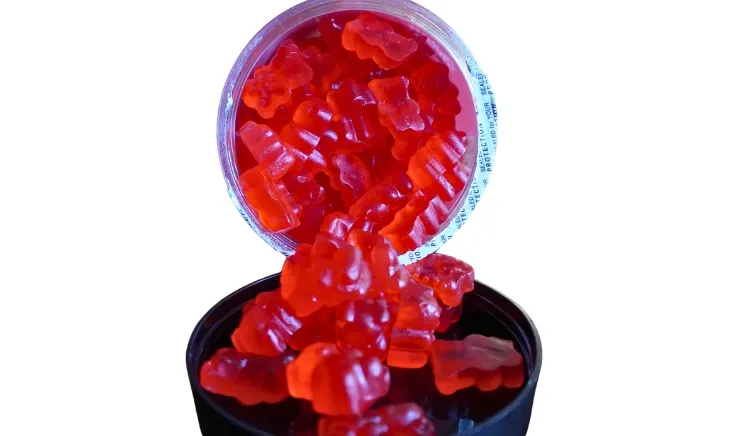 SWOLY's delicious creatine bites - Pouring gummies from jar into the lid