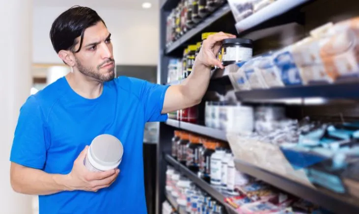 Man reaching for products on store shelf