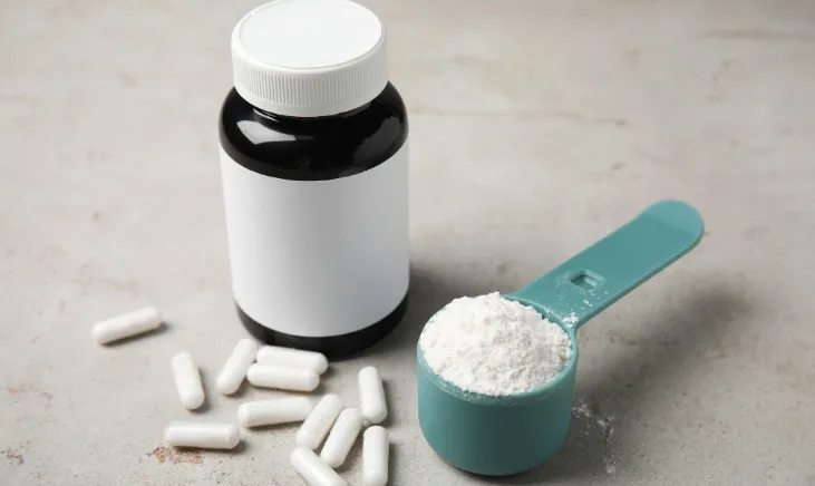 Tiny tablets and a bottle containing a scoop of white powder