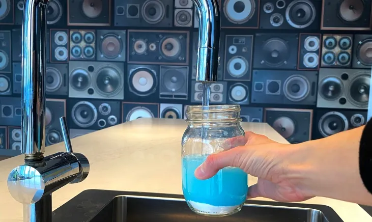 Blue Prosupps Hydro BCAA Drink in glass under a sink